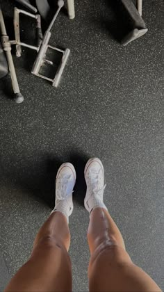 the legs and feet of a person who is standing in front of a gym machine