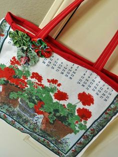 a red and white bag with flowers on it hanging from the side of a door