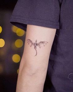 a small tattoo on the arm of a person with a bat in it's hand