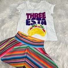 Dress Your Little One In Festive Fashion With The Three Esta Birthday Shirt And Serape Skirt, Perfect For Celebrating A Child's Third Birthday. The Outfit Includes A Vibrant Taco-Themed Shirt With Short Sleeves And A Comfortable Pullover Closure, Ensuring An Easy And Secure Fit. The Matching Serape Skirt Features A Playful Fiesta Pattern That's Sure To Make Any Party Even More Colorful. Designed For Both Comfort And Style, The Skirt And Shirt Are Made From A Lightweight Polyester Blend Fabric That's Machine Washable For Your Convenience. This Two-Piece Set Is Ideal For Both Casual Occasions And Birthday Festivities. With Its Non-Iron And Wrinkle-Resistant Properties, It Maintains A Neat And