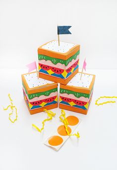 three slices of cake sitting on top of each other with flags sticking out of them