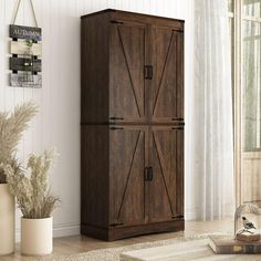 a tall wooden cabinet sitting on top of a rug in a living room next to a potted plant