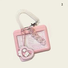 a pink bag with a heart shaped keychain attached to it's side