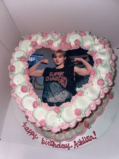 the birthday cake is decorated with pink and white frosting, roses and an image of one direction