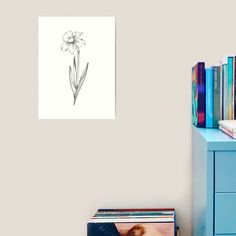 a drawing of a single flower on a white wall next to a blue dresser and bookshelf