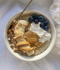 a bowl filled with oatmeal, bananas and blueberries