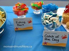 there are some snacks on the table with name tags in front of them, including fish and chips