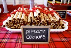 there is a display of diploma cookies on the table with a sign that says diploma cookies