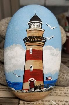 a painted rock with a lighthouse on it