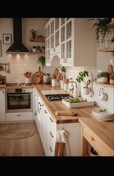 a kitchen filled with lots of wooden counter top next to white cabinets and counters topped with pots and pans