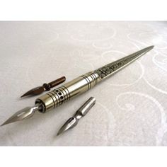 two pens sitting next to each other on top of a white tablecloth covered surface