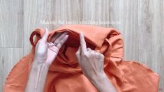 two hands reaching out from behind an orange cloth with the words making the under stitching seam here