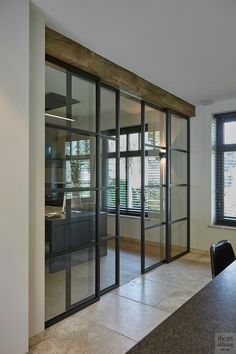 an empty room with sliding glass doors leading to the kitchen and dining area in it