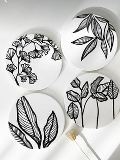 three plates with black and white designs on them