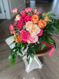 a vase filled with lots of different colored flowers