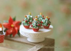 small christmas trees are sitting on a cake plate with cupcakes in the middle