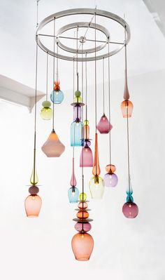 a chandelier with many different colored glass vases hanging from it's ceiling