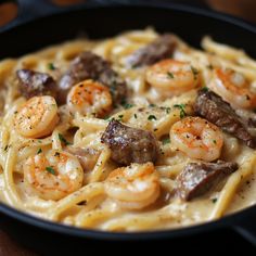 pasta with shrimp and sausage in a skillet on a wooden table, ready to be eaten