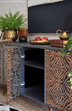 a black and white sideboard with some plants on it