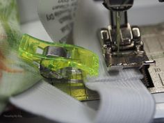 the sewing machine is working on the green ribbon that has been sewned into