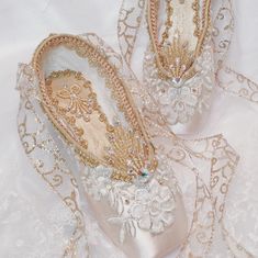 two pairs of white shoes with gold lace on them