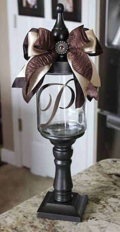 a glass vase with a bow on top of it