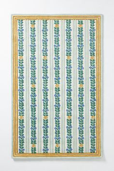 an image of a wall hanging with green and blue flowers on the outside of it