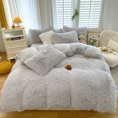 the bed is made up with fluffy blankets and pillows