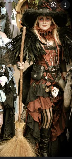 two women dressed in costumes and holding brooms, one wearing a hat with feathers