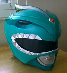 a blue helmet with large teeth on top of a wooden table