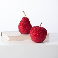 two red apples sitting on top of a book