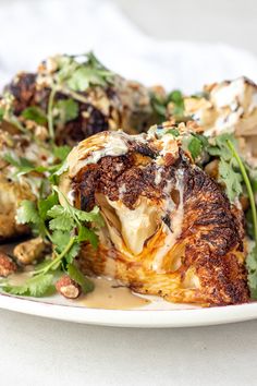 a white plate topped with cauliflower covered in sauce