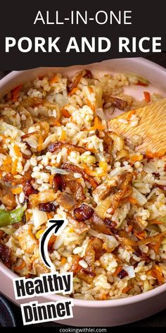 a bowl filled with rice and meat next to a wooden spoon on top of it