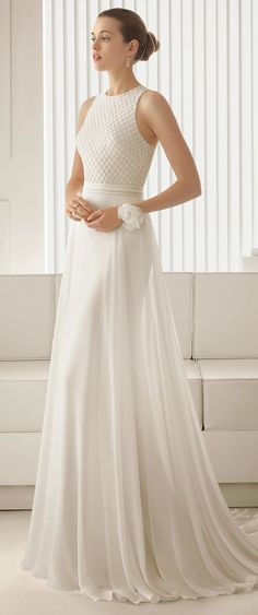 a woman in a white wedding dress is standing near a couch and looking off to the side