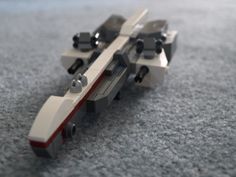 a lego model of a space shuttle on the ground with its wheels still attached to it