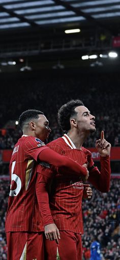 two men in red uniforms standing next to each other