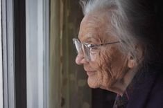 an elderly woman looking out the window