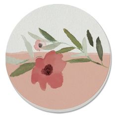 a pink flower with green leaves on the side of a round coaster that is painted in watercolor