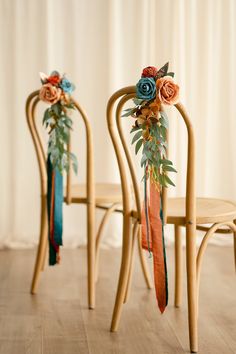 two wooden chairs decorated with flowers and ribbons