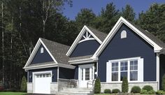 a blue house with white trim on the front and side windows, two car garage doors, and steps leading up to it