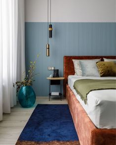 a bedroom with blue and green wallpaper in the corner