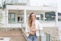 a woman standing on a balcony next to a building