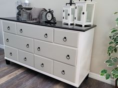 a white dresser with black top and drawers