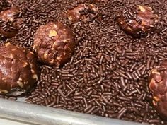 chocolate cookies are sitting on top of brown sprinkles in a baking pan