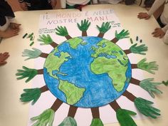 children sitting at a table with their hands on the earth