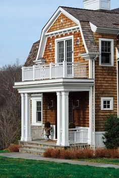 a brown and white house sitting on top of a lush green field