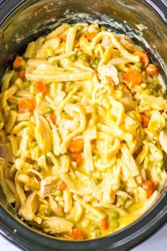 a crock pot filled with chicken noodle soup on top of a white table