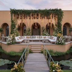 an outdoor seating area with couches and flowers on the steps leading up to it