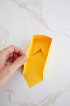 someone is folding an origami tie on the table