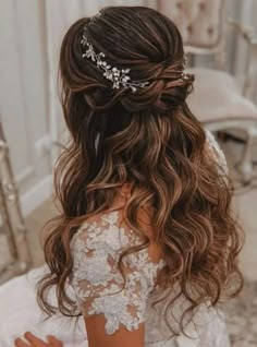 the back of a bride's head with her hair in half - up style